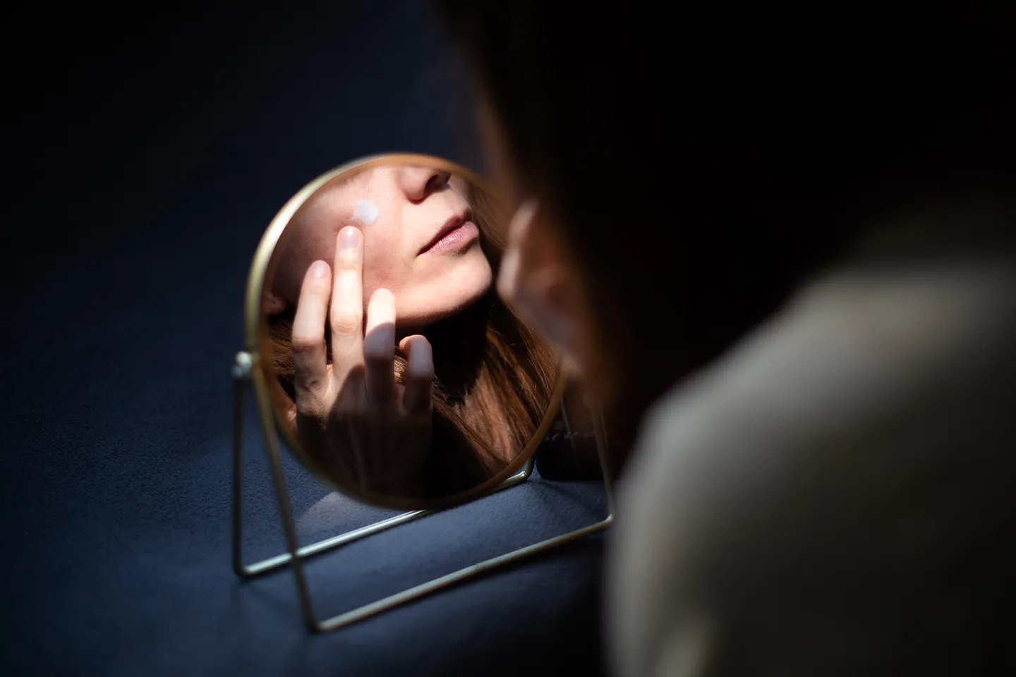 A woman applying salmon sperm solution to her face